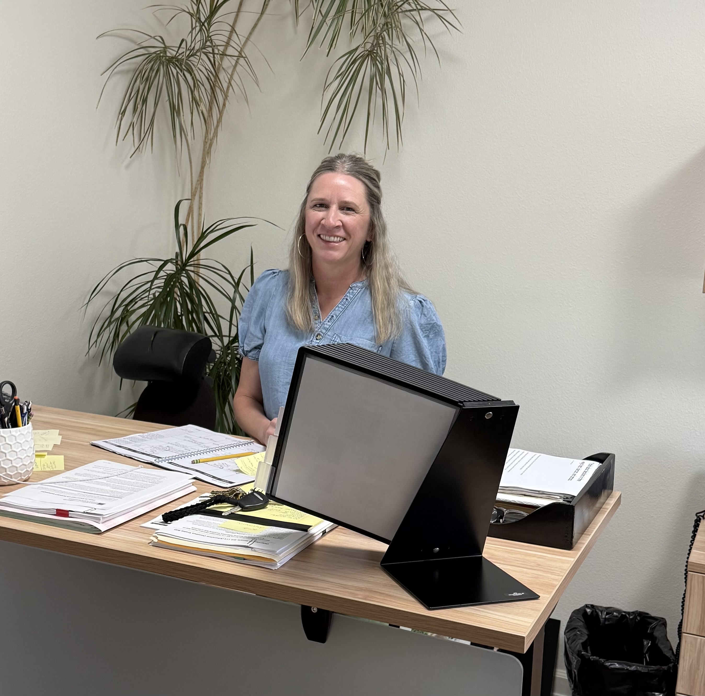 Superintendent Amy Betts sitting at her desk and smiling
